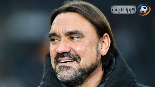 حارس مرمى يمسك ركبته على أرض الملعب بينما يتجمع اللاعبون حول المدرب، يرمز لجدل تمثيل الإصابات في كرة القدم.